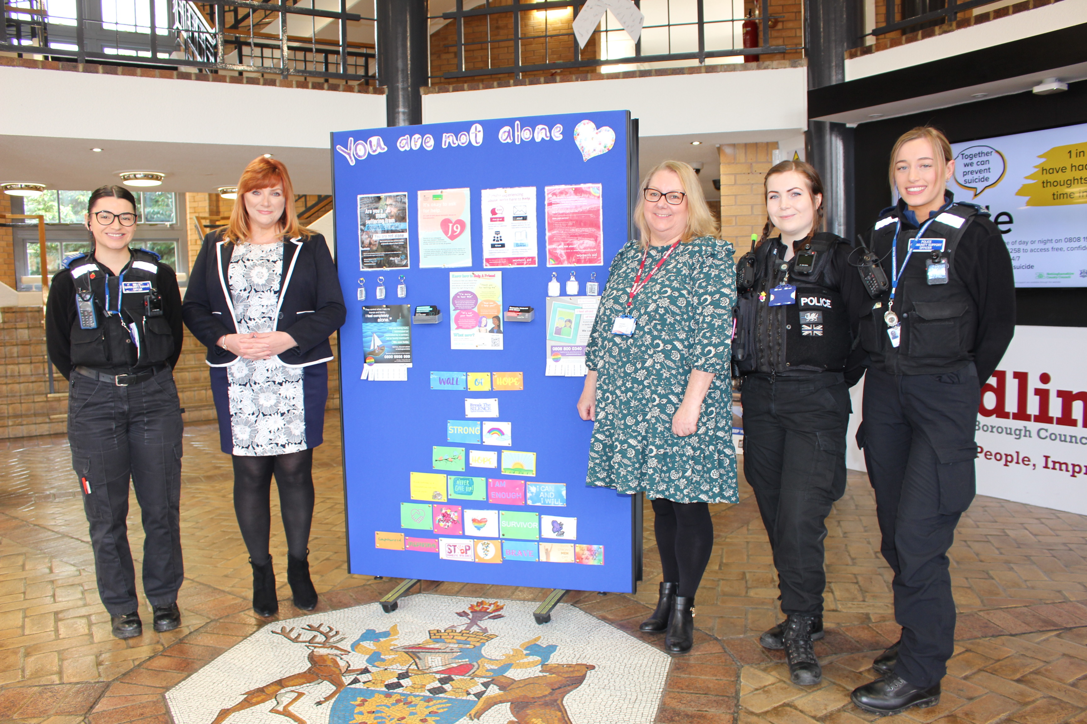 Staff with Police in front of the domestic violence support board